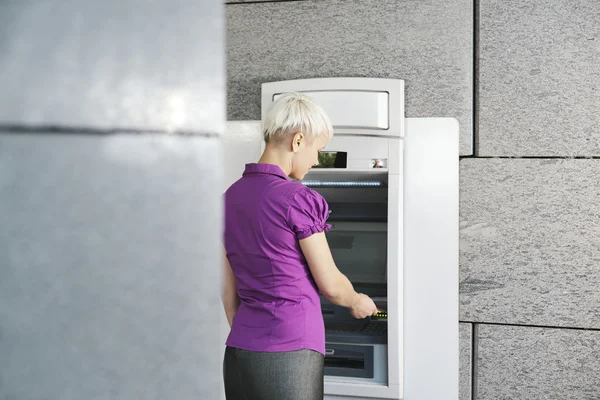 Молодая женщина, снятия денег с карты в банкомате — стоковое фото