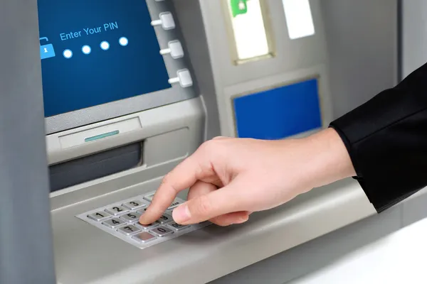 Человек вводит PIN-код и снимает деньги в банкомате — стоковое фото