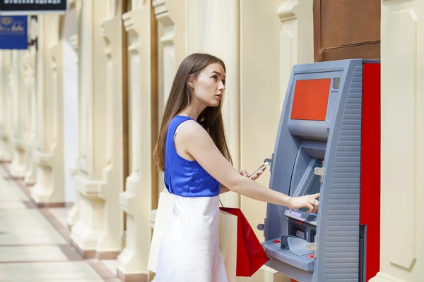 Счастливая женщина брюнетка, снятие денег с кредитной карты в банкомате — стоковое фото
