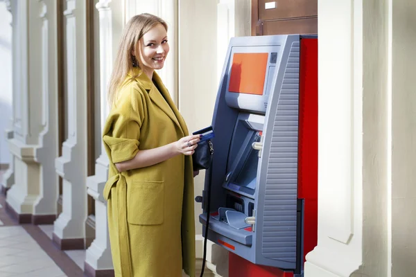 Blonde Dame mit einem Geldautomaten — стоковое фото