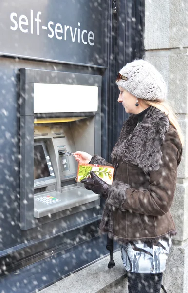 Девушка в банкомате, вид сбоку — стоковое фото