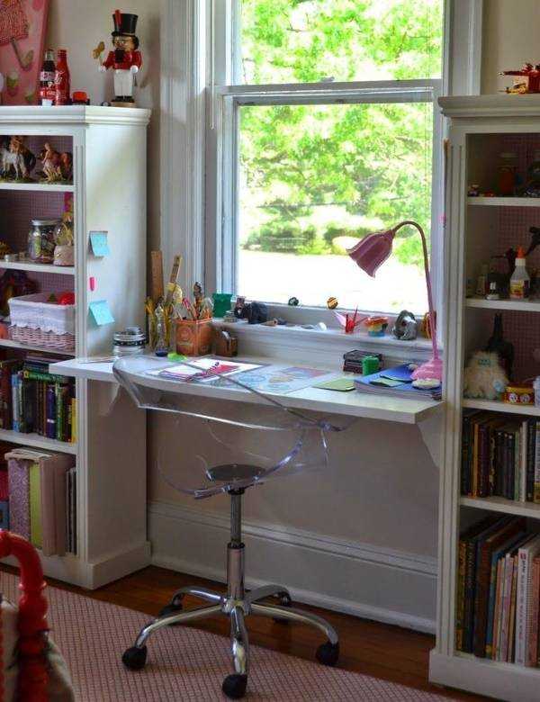 Письменный стол с подоконником и шкафами по бокам в детской