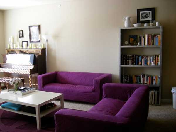 Темно фиолетовый диван в интерьере гостиной