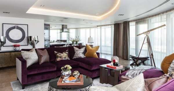 Темно фиолетовый диван в интерьере гостиной
